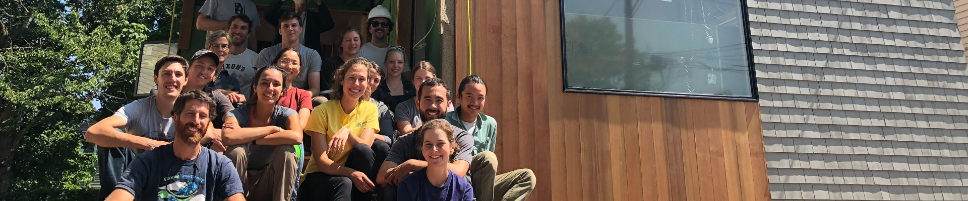 Group of people sitting on the stairs to the entrance of a house
