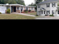 Front of brick shelter building and the front of a white shelter building
