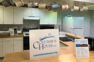 interior of a kitchen with a sign that has the columbus house logo