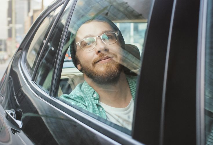 Man looking longingly out a car window