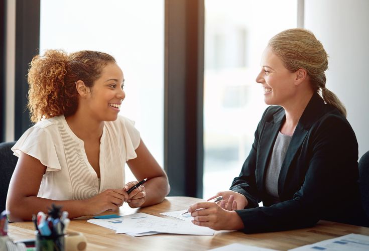 Two women discussing paperwork