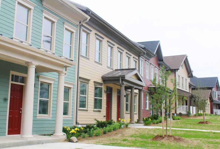 Neighborhood of colorful houses with flowerbeds and trees