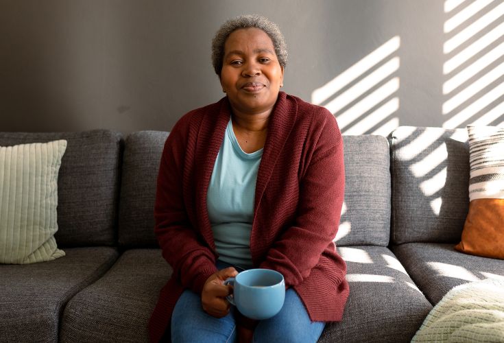 Woman holding a mug while sitting on a couch