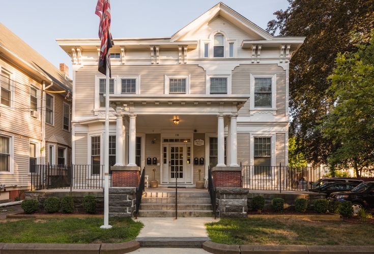 Front of Harkness House. There is a flag pole in the front yard with an American flag