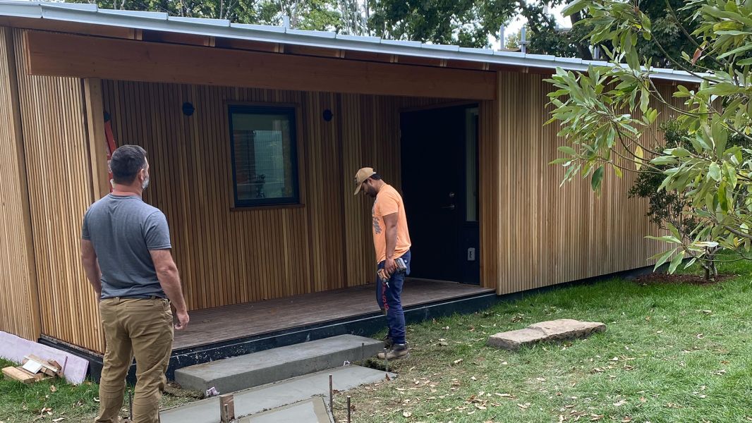 Construction worker standing on front of house with a power drill in his hand
